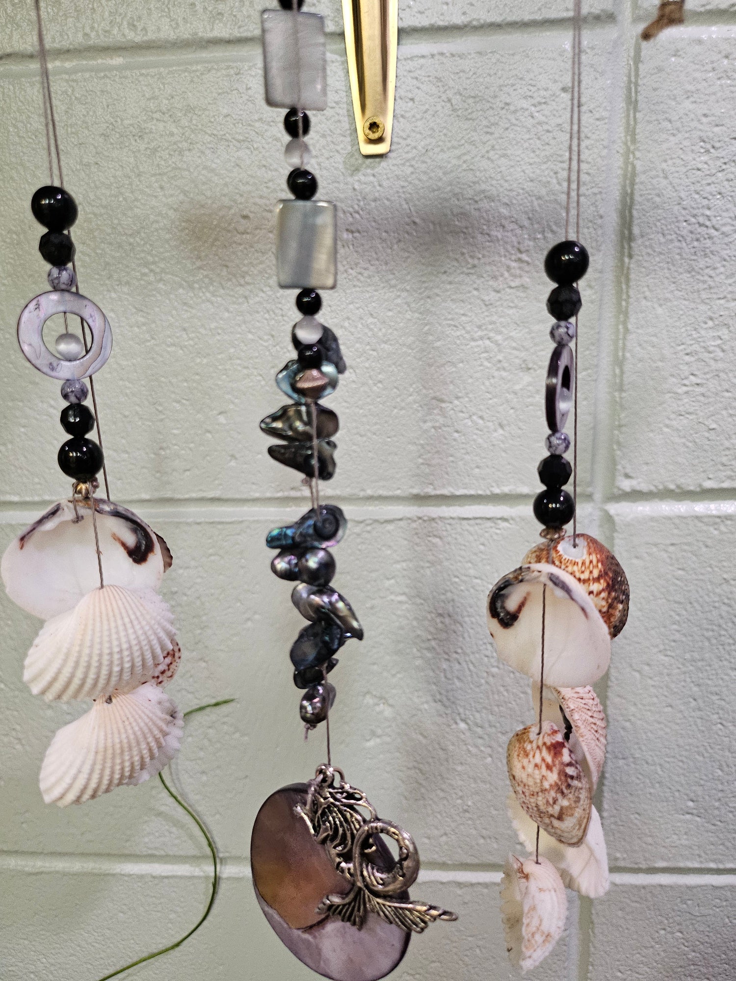 Add coastal charm to your space with the Shell &amp; Bead Bohemian Suncatcher. Handcrafted with natural shells, semi-precious stones, and beads, it captures sunlight to create a stunning display of light and texture, perfect for windows, gardens, or as a unique, nature-inspired gift.