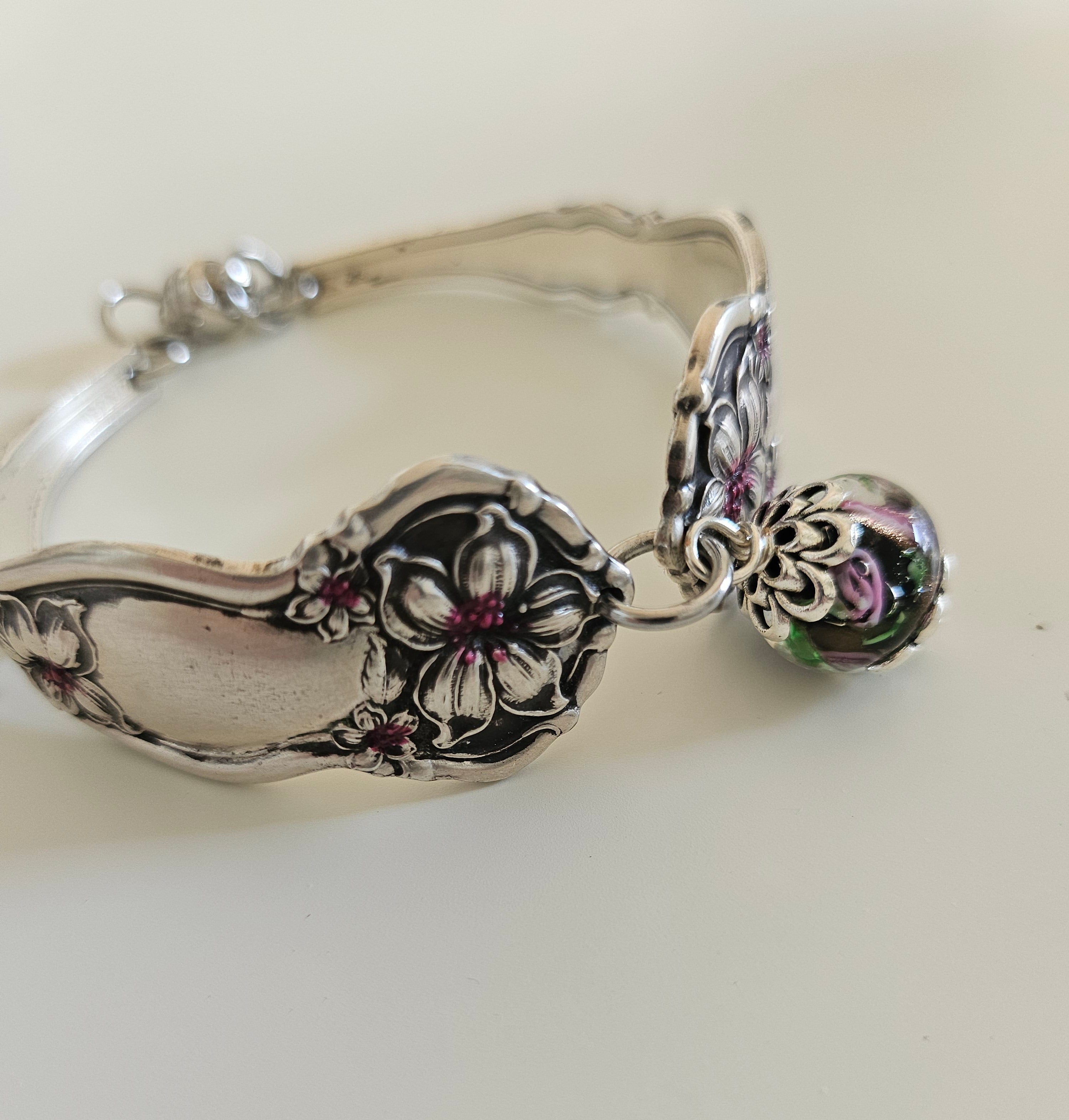 Handcrafted from 1910 Wm. Rogers silverware, this vintage Orange Blossom bracelet features glass beads, a magnetic clasp, and timeless floral charm.