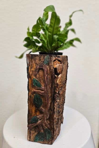 This Hand-Carved &amp; Painted Wood Spirit Planter in solid walnut features intricate details and black-painted accents. 100% handmade, each piece is unique and perfect for home decor or garden. The natural walnut grain and artisanal craftsmanship add rustic charm, making it a standout decorative piece for any space.
