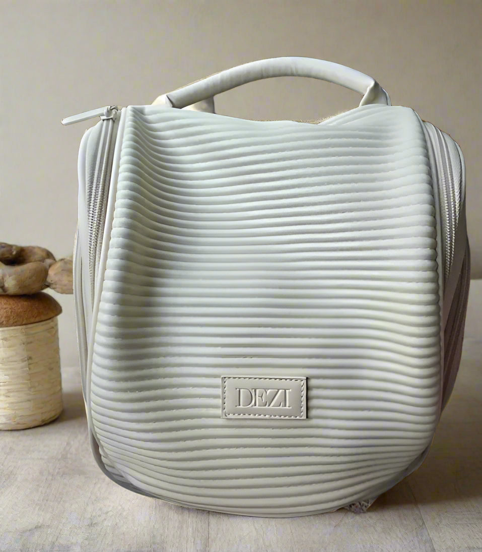 Spacious Dezi Skin travel bag with compartments, side pockets, 360° hook &amp; easy-clean lining. Fits full-size products—perfect for beauty, gym, or travel.