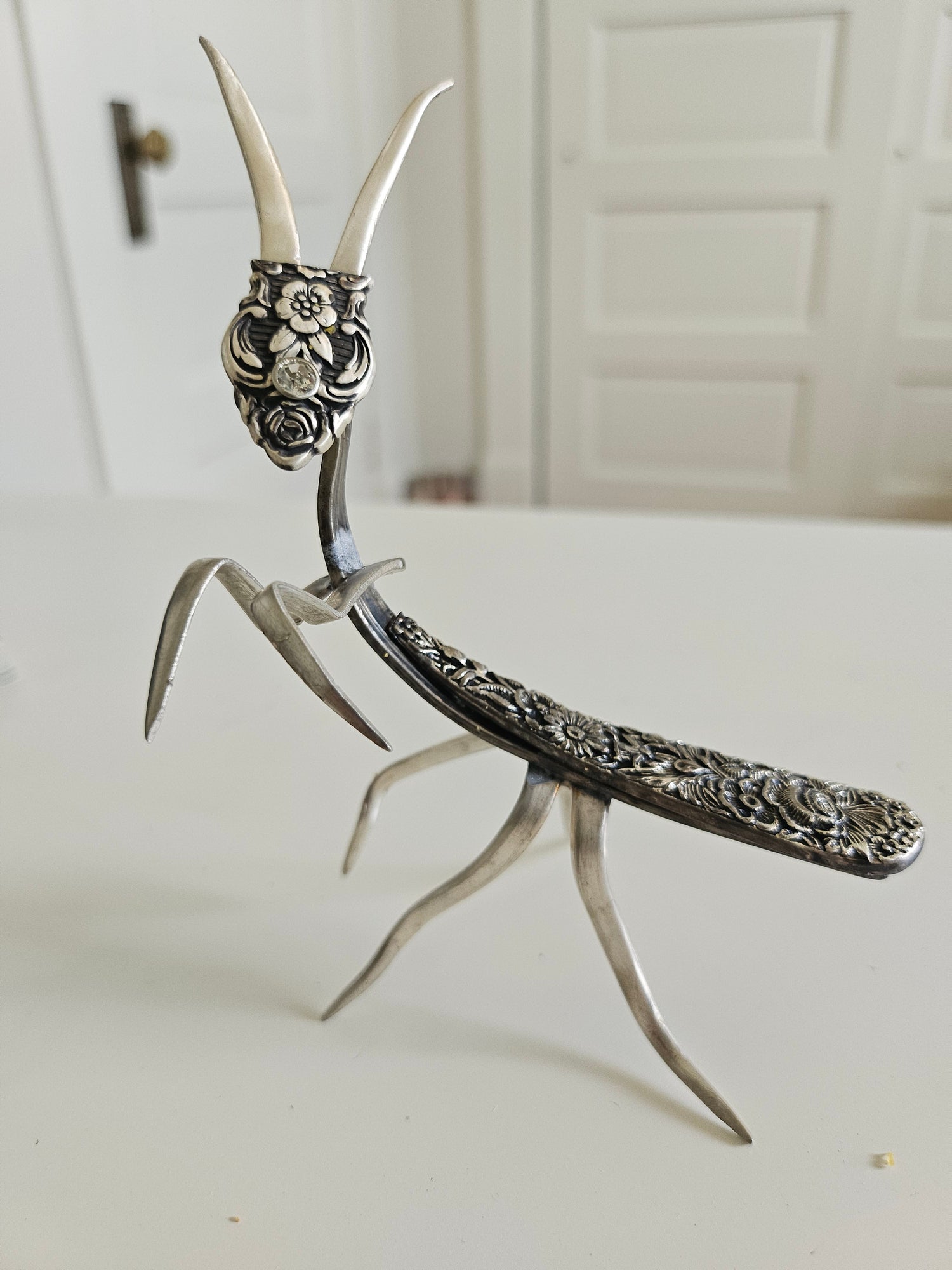 Handcrafted 5&quot; x 4&quot; praying mantis sculpture made from vintage silverware. Unique, whimsical art with gemstone accents and aged patina for mindful décor.