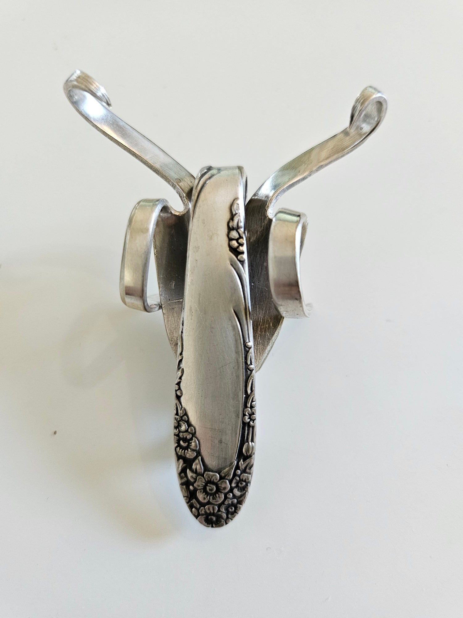 The Lucky Fork Cricket is a handcrafted sculpture made from repurposed vintage silverware, blending artistry with charm. Inspired by crickets—symbols of luck and prosperity—each piece is unique, adorned with jewels and aged patina. A perfect collectible or gift, this whimsical creation brings history, elegance, and positive energy to any space. 