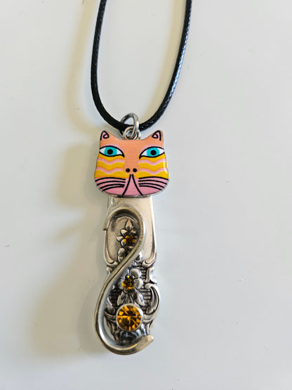 Handcrafted vintage silverware necklaces featuring enamel cat faces on adjustable satin cords. Made from 1951 Distinction and 1952 Primrose patterns.