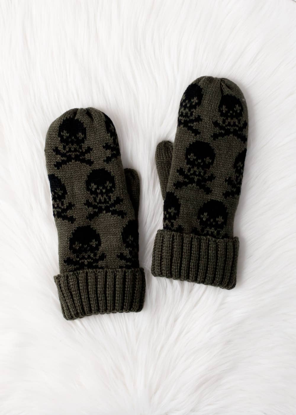 Olive skull patterned knit mittens with cozy fleece lining. Made from 100% acrylic for warmth and durability. Bold winter style pairs with matching hat.