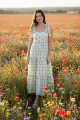 Romantic floral stripe midi dress with tie straps, square neckline, smocked back, and tiered ruffle details. Soft, feminine, and effortlessly elegant.