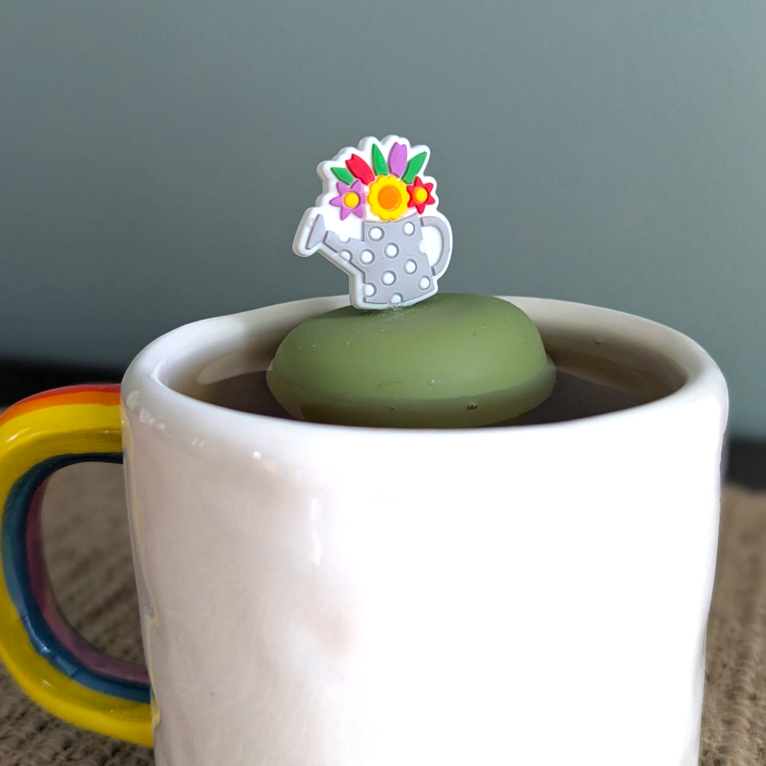 Floral watering can tea infuser with silicone and stainless steel mesh. Reusable, cute, and perfect for loose leaf tea lovers. Fits most mugs.