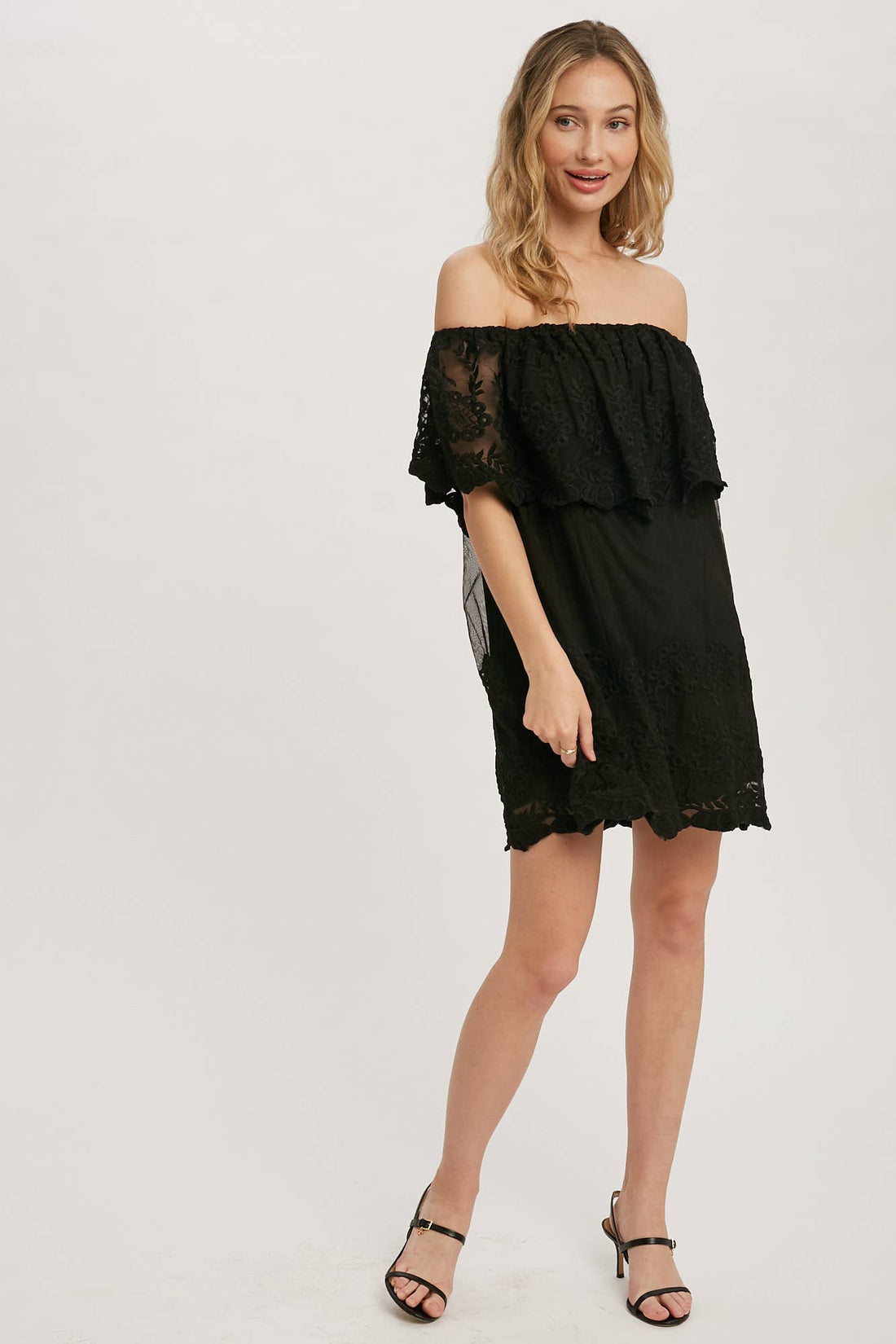 Off-the-shoulder floral lace mini dress with elastic neckline and swingy flounce silhouette. Romantic woven lace, scalloped hem, feminine fit.