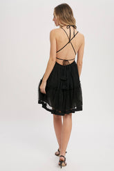 Black gauze swing mini dress with halter tie bust, backless design, elastic waist, and mesh ruffle hem. Lightweight summer party dress.