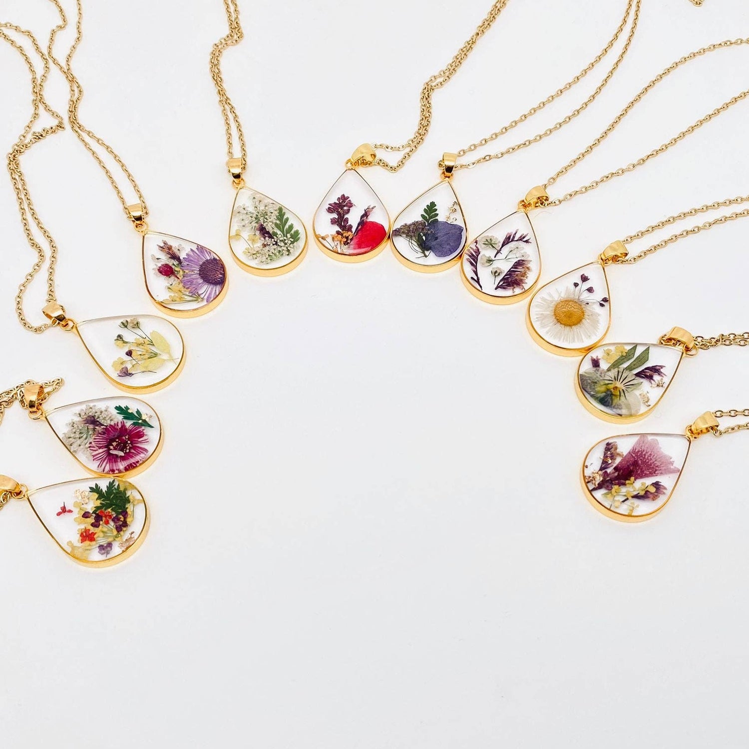 Teardrop necklace with real pressed dried flowers in resin. Unique floral charm with stainless steel chain and copper frame. Nature-inspired and handcrafted.