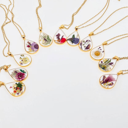 Teardrop necklace with real pressed dried flowers in resin. Unique floral charm with stainless steel chain and copper frame. Nature-inspired and handcrafted.