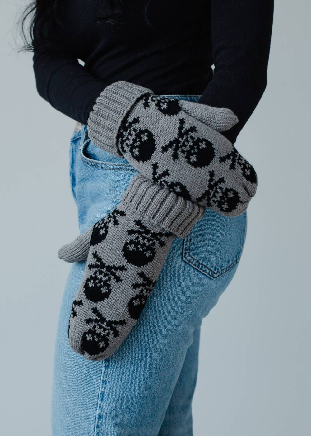 Gray skull patterned knit mittens with cozy fleece lining. Made from 100% acrylic for warmth and comfort. A bold, stylish essential for cold winter days.