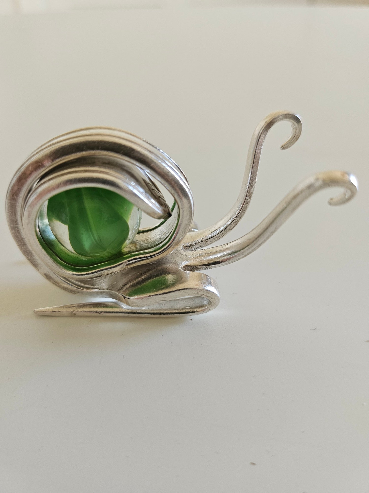 Handcrafted from vintage silverware, these whimsical snails feature shimmering glass orb shells—each a one-of-a-kind symbol of patience and charm.