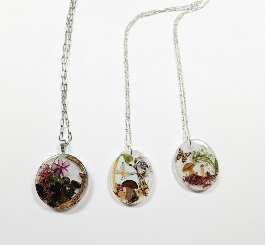 Handcrafted terrarium necklace featuring preserved botanicals and moss, creating a miniature garden you can wear. Each piece is one of a kind.