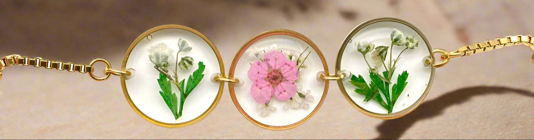 Handmade floral charm bracelet with real pressed Baby’s Breath, Daffodil, Queen Anne’s Lace, and Fern in resin. Adjustable 18K gold-plated stainless steel chain.