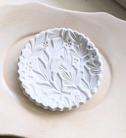 Handmade white polymer clay dish with a botanical impression. Perfect for holding rings, earrings, or small treasures. Unique, durable, and decorative.