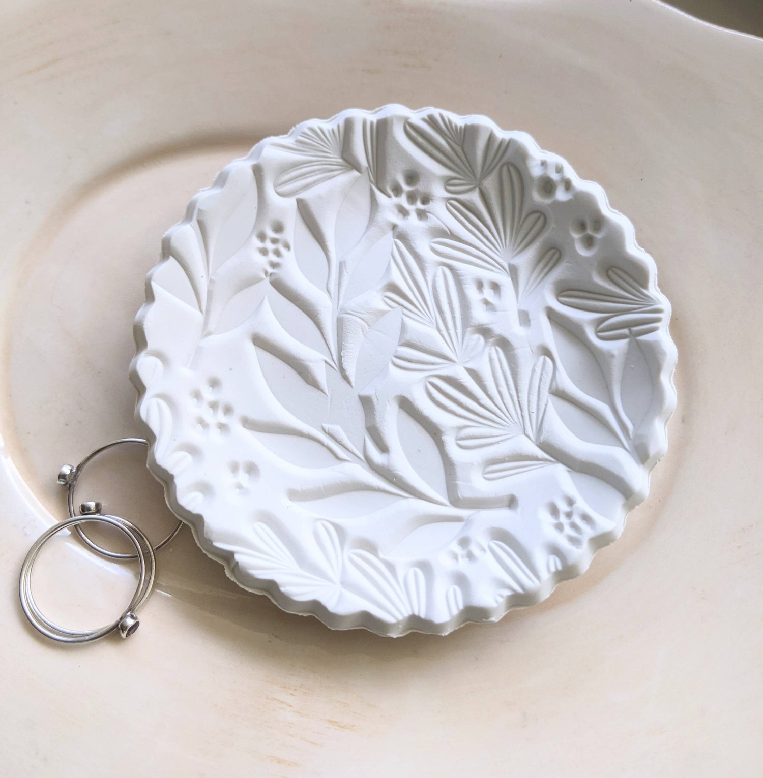 Handmade white polymer clay dish with a botanical impression. Perfect for holding rings, earrings, or small treasures. Unique, durable, and decorative.
