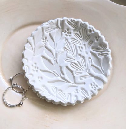 Handmade white polymer clay dish with a botanical impression. Perfect for holding rings, earrings, or small treasures. Unique, durable, and decorative.