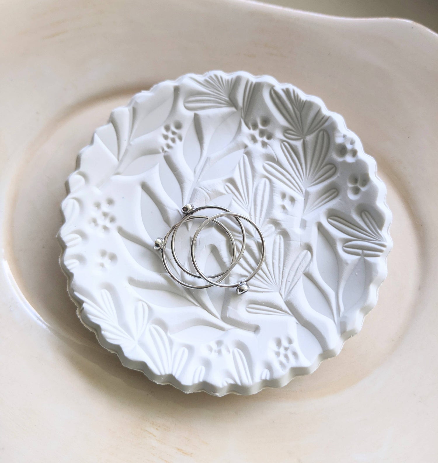 Handmade white polymer clay dish with a botanical impression. Perfect for holding rings, earrings, or small treasures. Unique, durable, and decorative.
