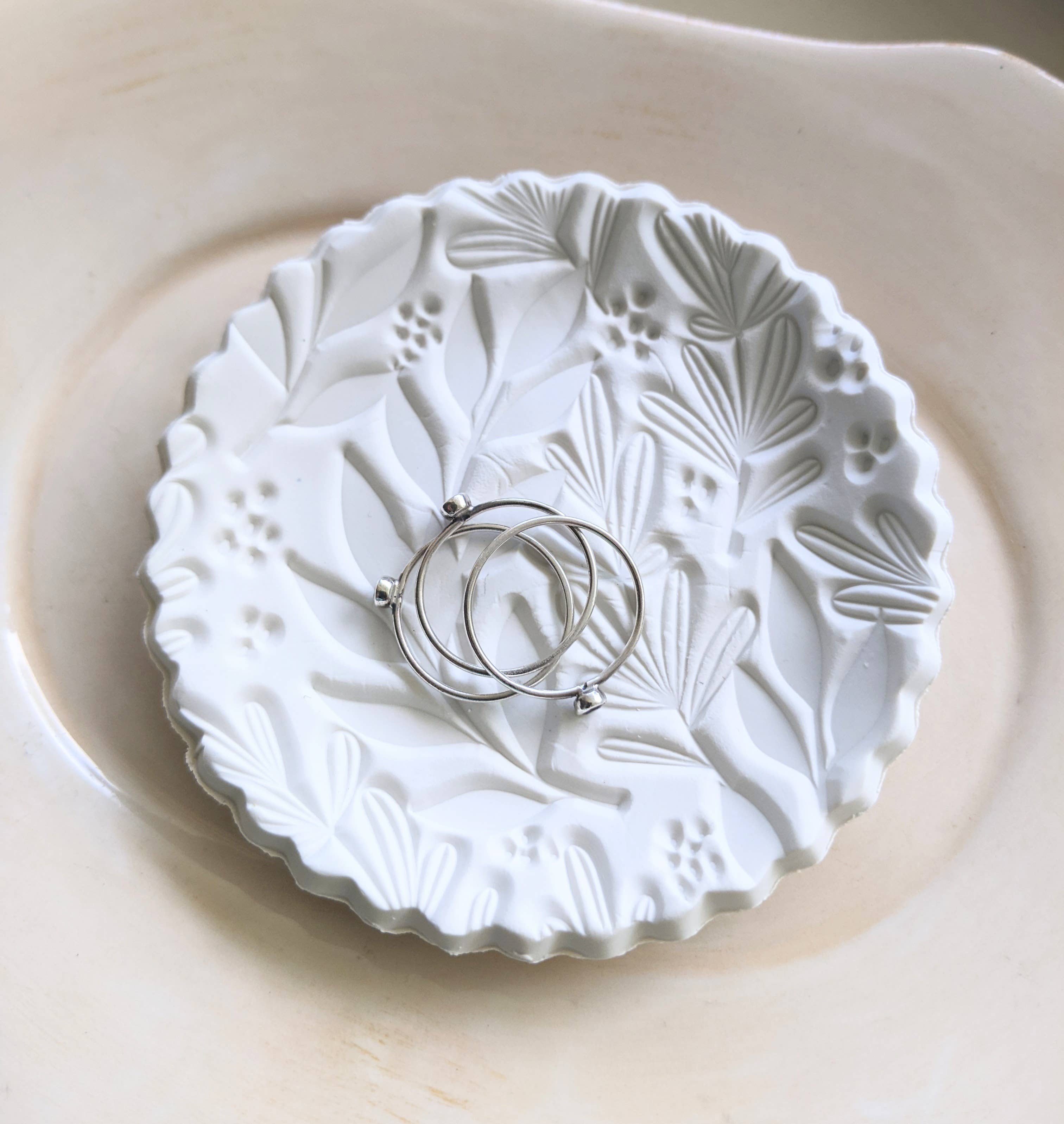 Handmade white polymer clay dish with a botanical impression. Perfect for holding rings, earrings, or small treasures. Unique, durable, and decorative.