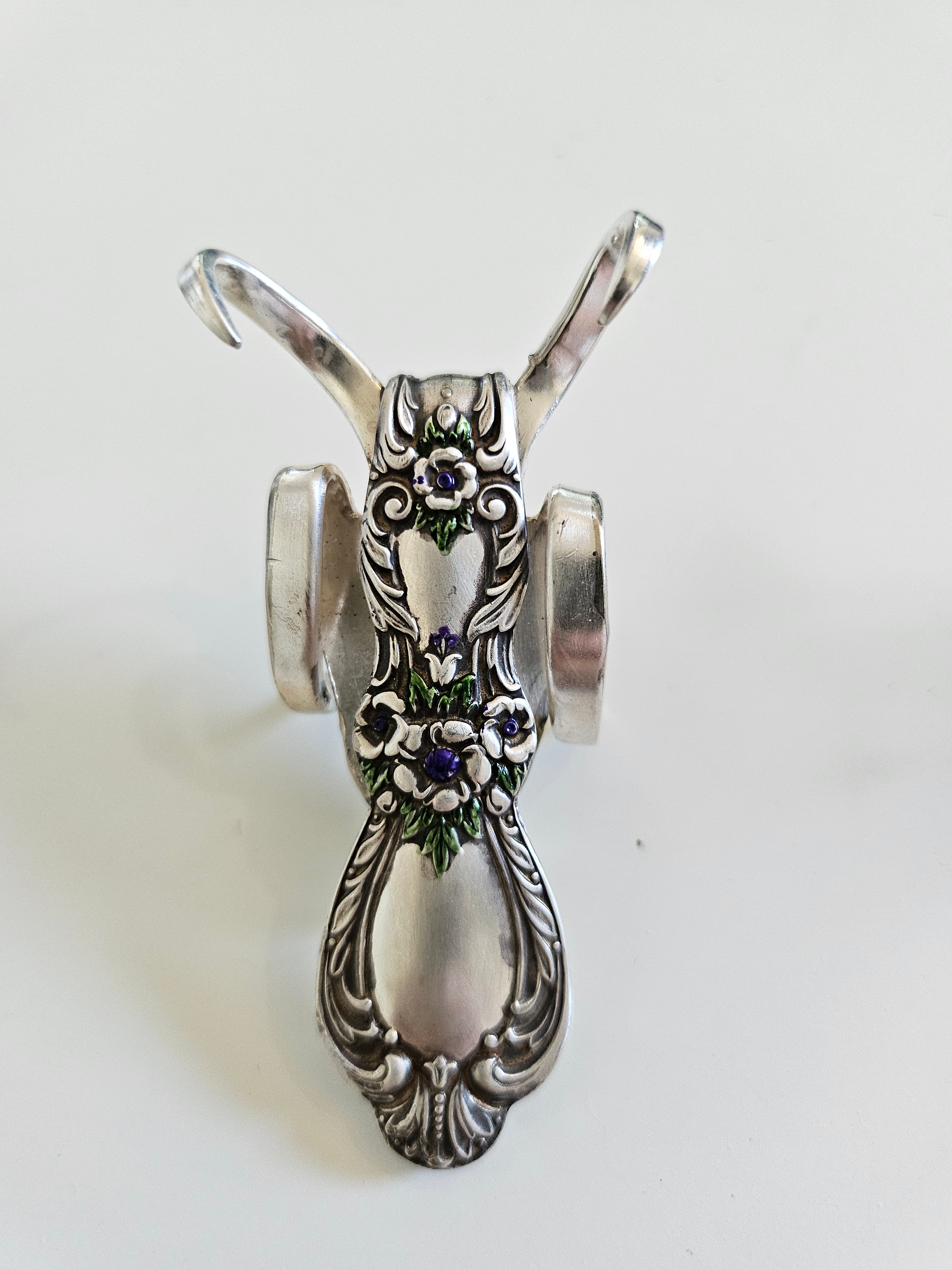 The Lucky Fork Cricket is a handcrafted sculpture made from repurposed vintage silverware, blending artistry with charm. Inspired by crickets—symbols of luck and prosperity—each piece is unique, adorned with jewels and aged patina. A perfect collectible or gift, this whimsical creation brings history, elegance, and positive energy to any space. 