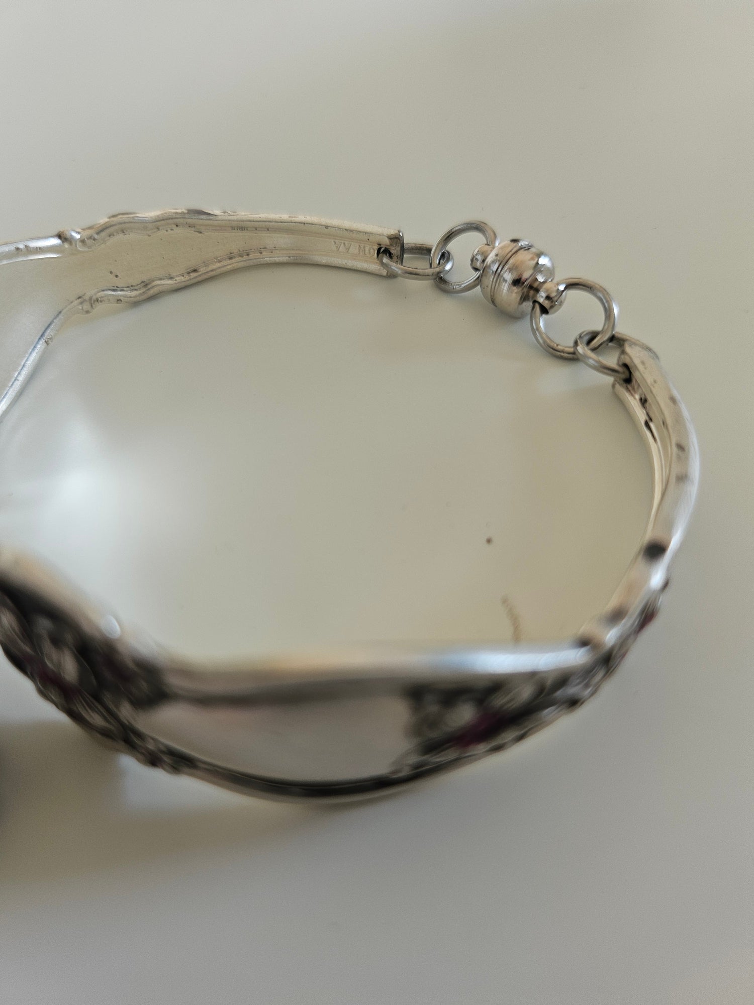 Handcrafted from 1910 Wm. Rogers silverware, this vintage Orange Blossom bracelet features glass beads, a magnetic clasp, and timeless floral charm.