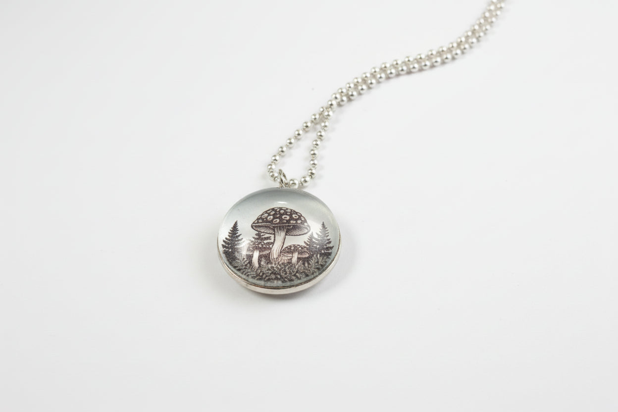 Handcrafted nature scene necklaces with real botanicals in iridescent and clear resin. Unique, wearable landscapes on chain or satin cord.