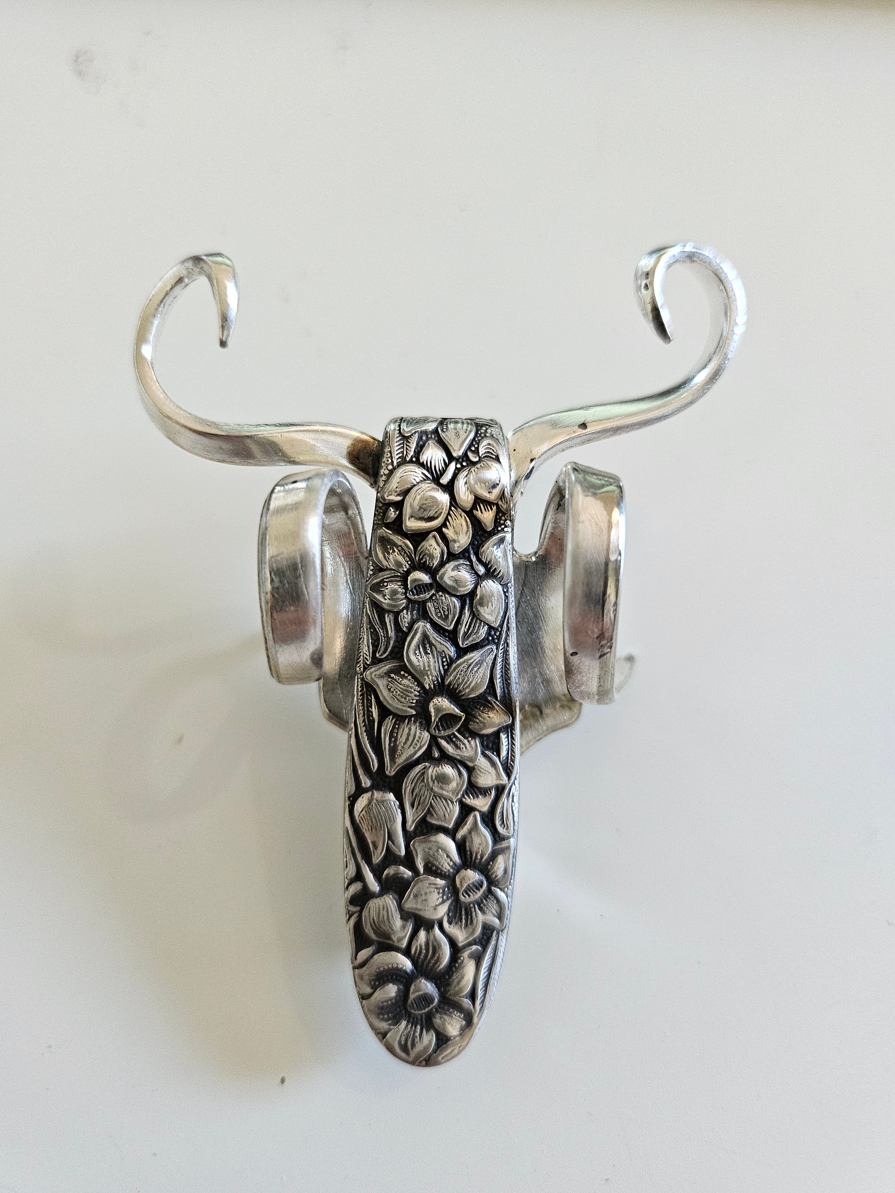 The Lucky Fork Cricket is a handcrafted sculpture made from repurposed vintage silverware, blending artistry with charm. Inspired by crickets—symbols of luck and prosperity—each piece is unique, adorned with jewels and aged patina. A perfect collectible or gift, this whimsical creation brings history, elegance, and positive energy to any space. 