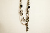 Layered antique-style chains with earthy beads and a charm tassel. The Nomad Layer Necklace is a soulful, wander-inspired statement.