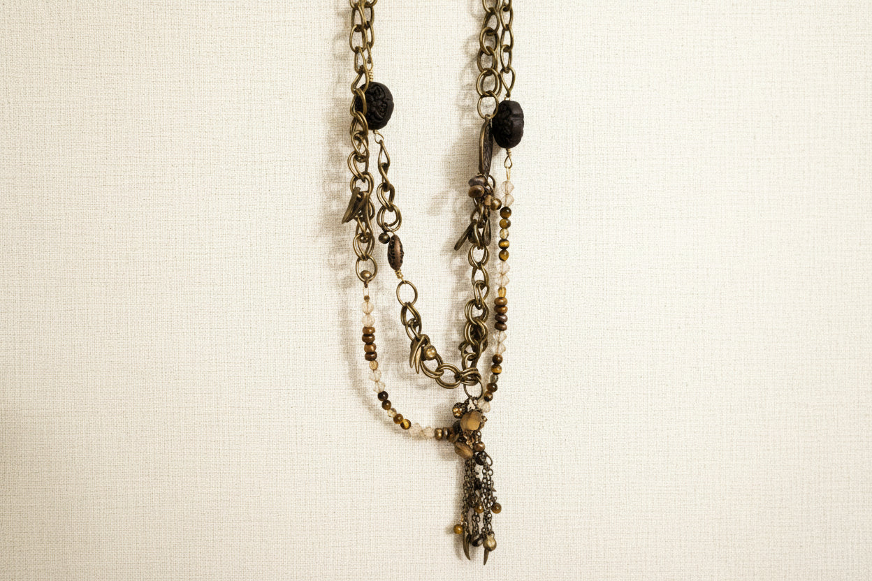 Layered antique-style chains with earthy beads and a charm tassel. The Nomad Layer Necklace is a soulful, wander-inspired statement.