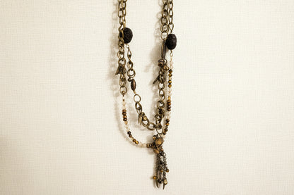 Layered antique-style chains with earthy beads and a charm tassel. The Nomad Layer Necklace is a soulful, wander-inspired statement.