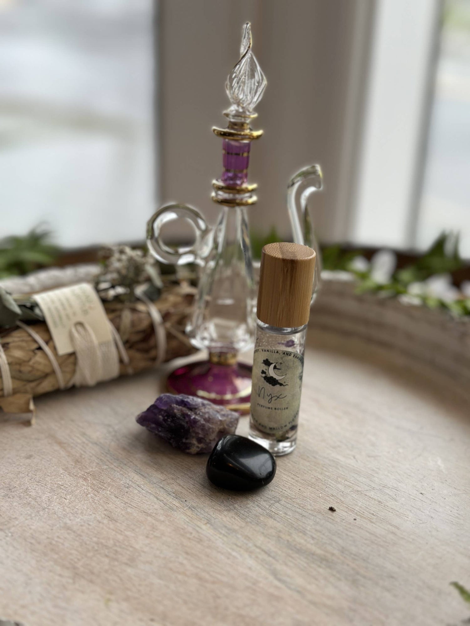 Nyx Goddess Perfume Roller with coconut oil, black obsidian &amp; mallow flower. Oriental and almond notes create a mystical, night-inspired aura.