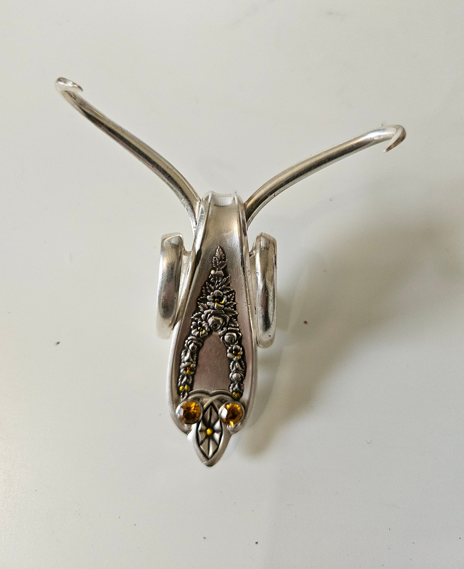 The Jeweled Lucky Fork Cricket is a whimsical, handcrafted sculpture made from repurposed vintage silverware. Each unique piece, shaped from antique forks, captures the charm of crickets—symbols of luck, prosperity, and protection. Adorned with jewels and aged patina, these one-of-a-kind collectibles add artistry, history, and positive energy to any space. 