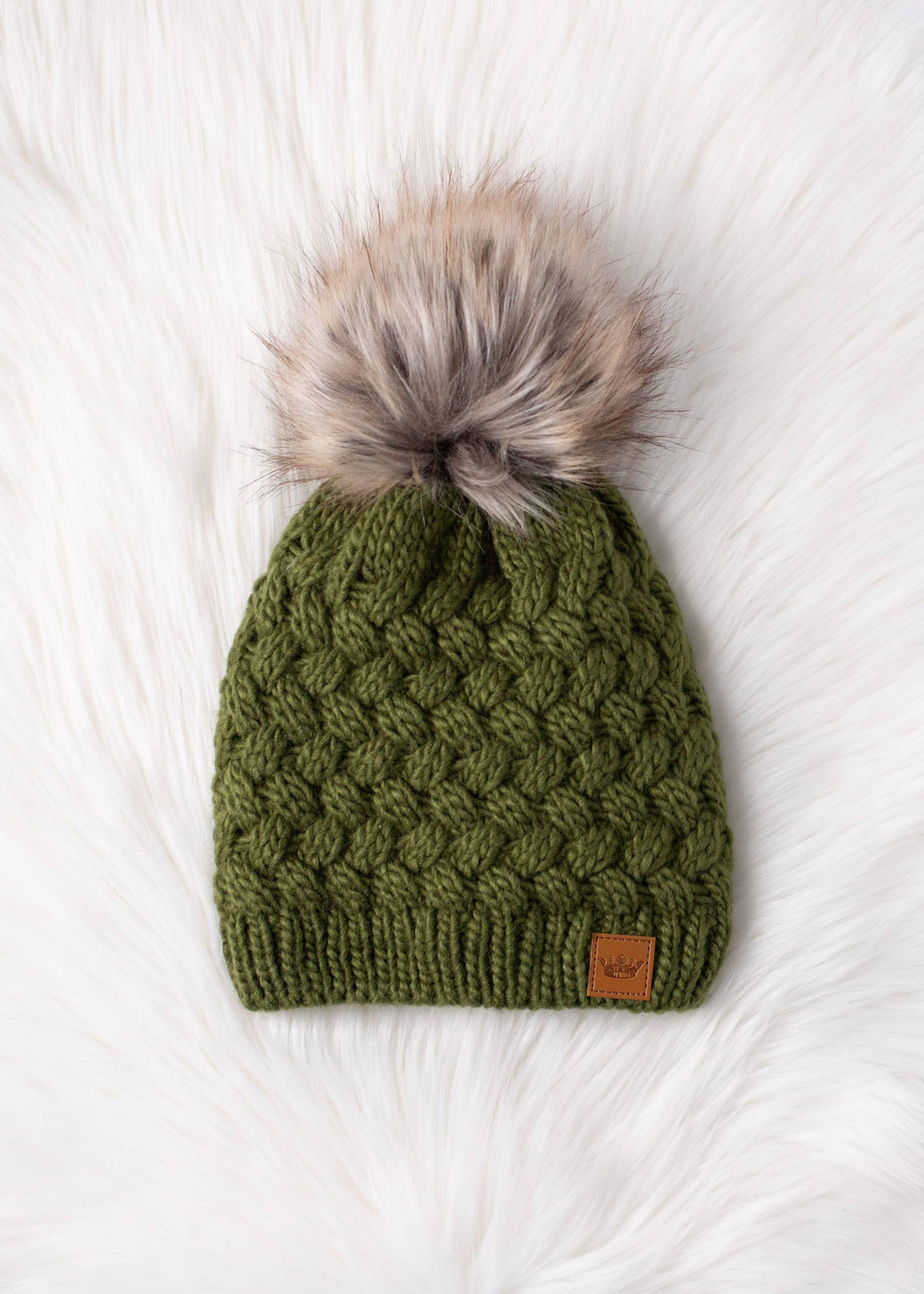 Olive green knit hat with natural faux fur pom. Cozy, stylish, and versatile—crafted from 100% acrylic for warmth and everyday boho-chic winter vibes.