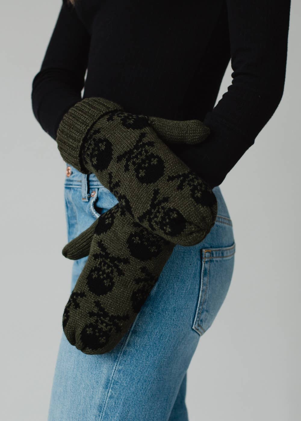 Olive skull patterned knit mittens with cozy fleece lining. Made from 100% acrylic for warmth and durability. Bold winter style pairs with matching hat.