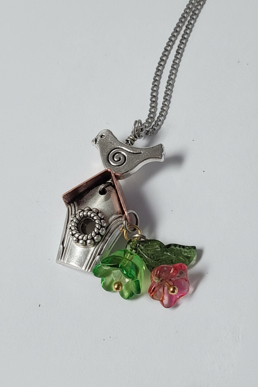 Handcrafted small birdhouse necklace made from reclaimed vintage silverware. Whimsical, cottagecore, eco-friendly jewelry perfect for nature lovers and unique gift giving.
