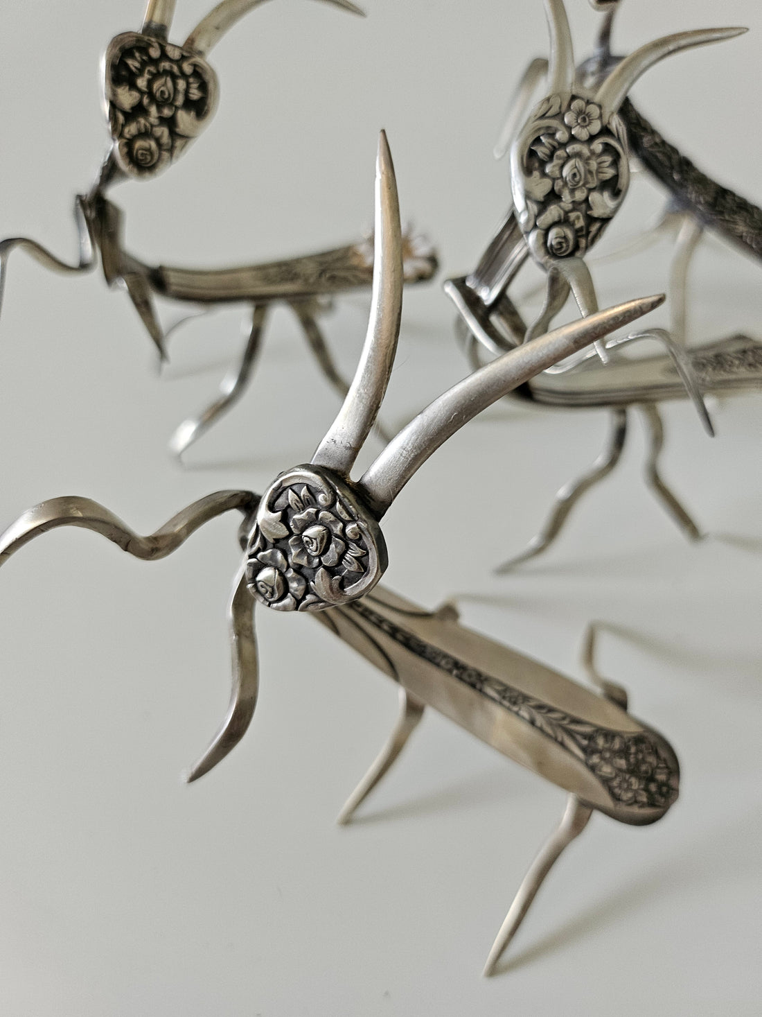 Handcrafted 5" x 4" praying mantis sculpture made from vintage silverware. Unique, whimsical art with gemstone accents and aged patina for mindful décor.