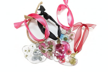Pressed flower resin suncatcher ornaments with real botanicals in heart, butterfly, and organic shapes—handmade, one-of-a-kind nature keepsakes by Angel Singh.