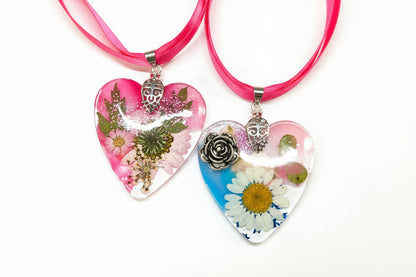 Pressed flower resin suncatcher ornaments with real botanicals in heart, butterfly, and organic shapes—handmade, one-of-a-kind nature keepsakes by Angel Singh.