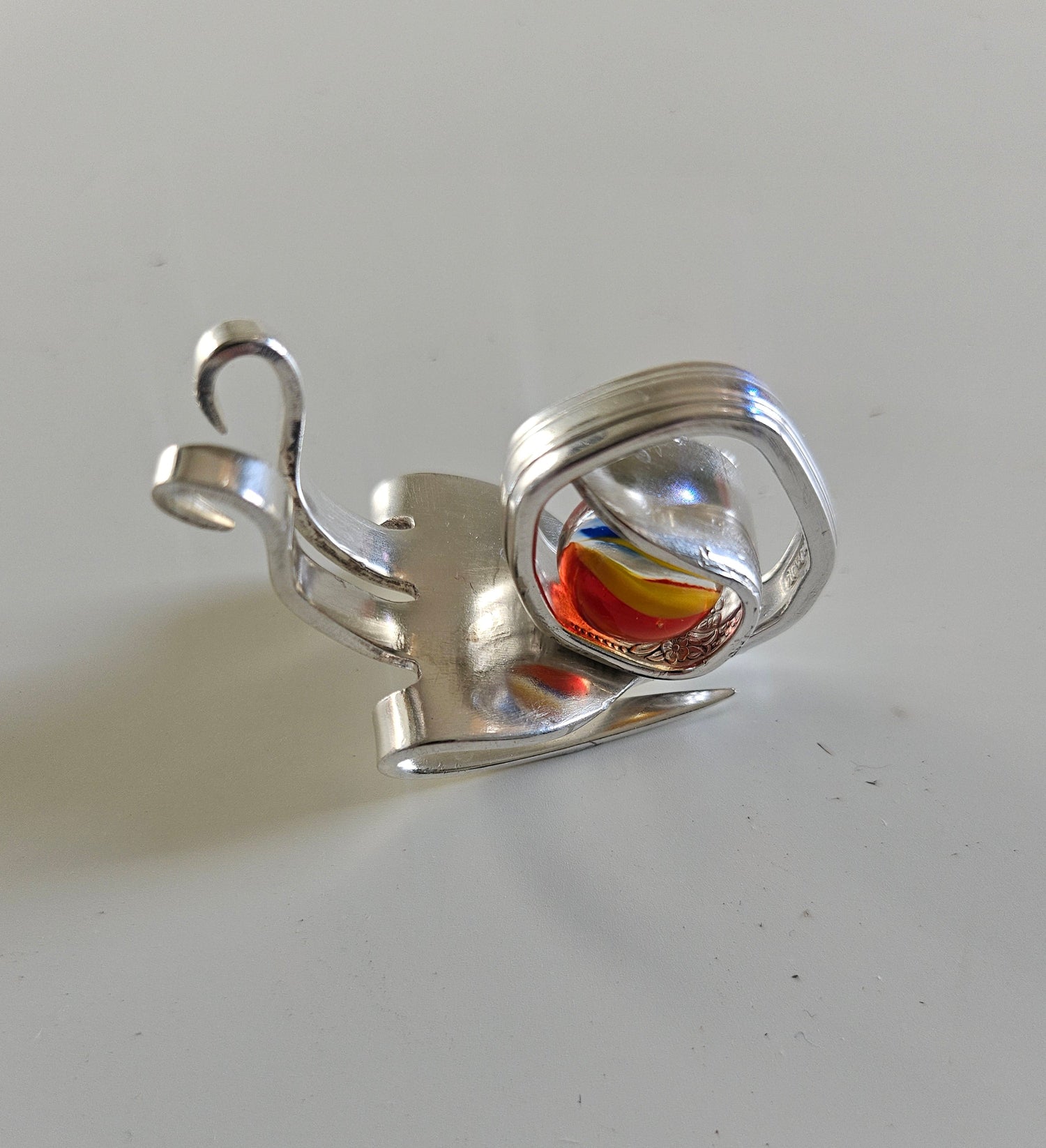 Handcrafted from vintage silverware, these whimsical snails feature shimmering glass orb shells—each a one-of-a-kind symbol of patience and charm.