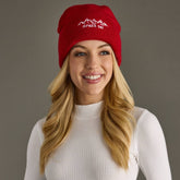 Red knit beanie with white embroidered Apres Ski text and graphic on the cuff. Fleece lined and made from 100% acrylic for cozy, playful winter style.
