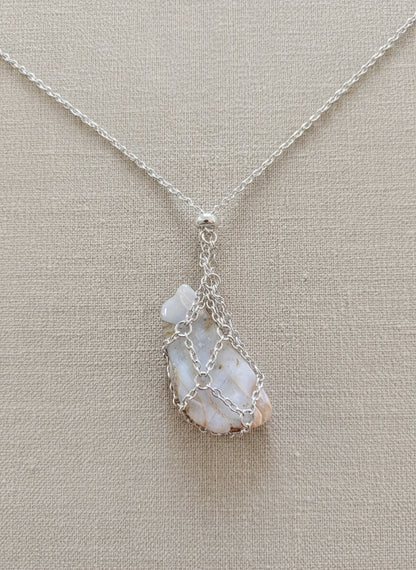 A versatile Crystal and Rock Cage Necklace with an adjustable metal pendant. Swap in your favorite gemstones or charms for a personalized, mystical accessory.