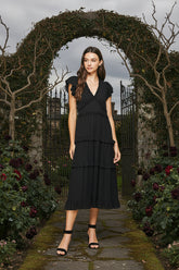 Romantic and timeless, the PINCH Ruffled Tea-Length Dress features tiered layers, flutter sleeves, and a smocked back waistband for a flattering, effortless fit.