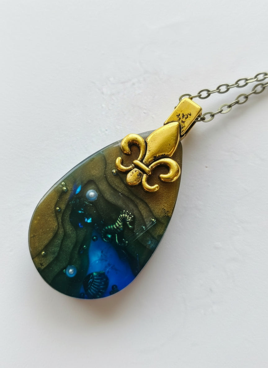Sea Life Resin Pendant Necklaces by artist KStonely featuring shells, fish, jellyfish, and sea life miniatures in dreamy blue, brown, and gold ocean-inspired resin.