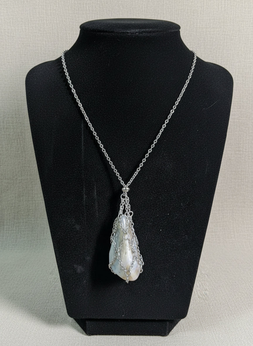 A versatile Crystal and Rock Cage Necklace with an adjustable metal pendant. Swap in your favorite gemstones or charms for a personalized, mystical accessory.