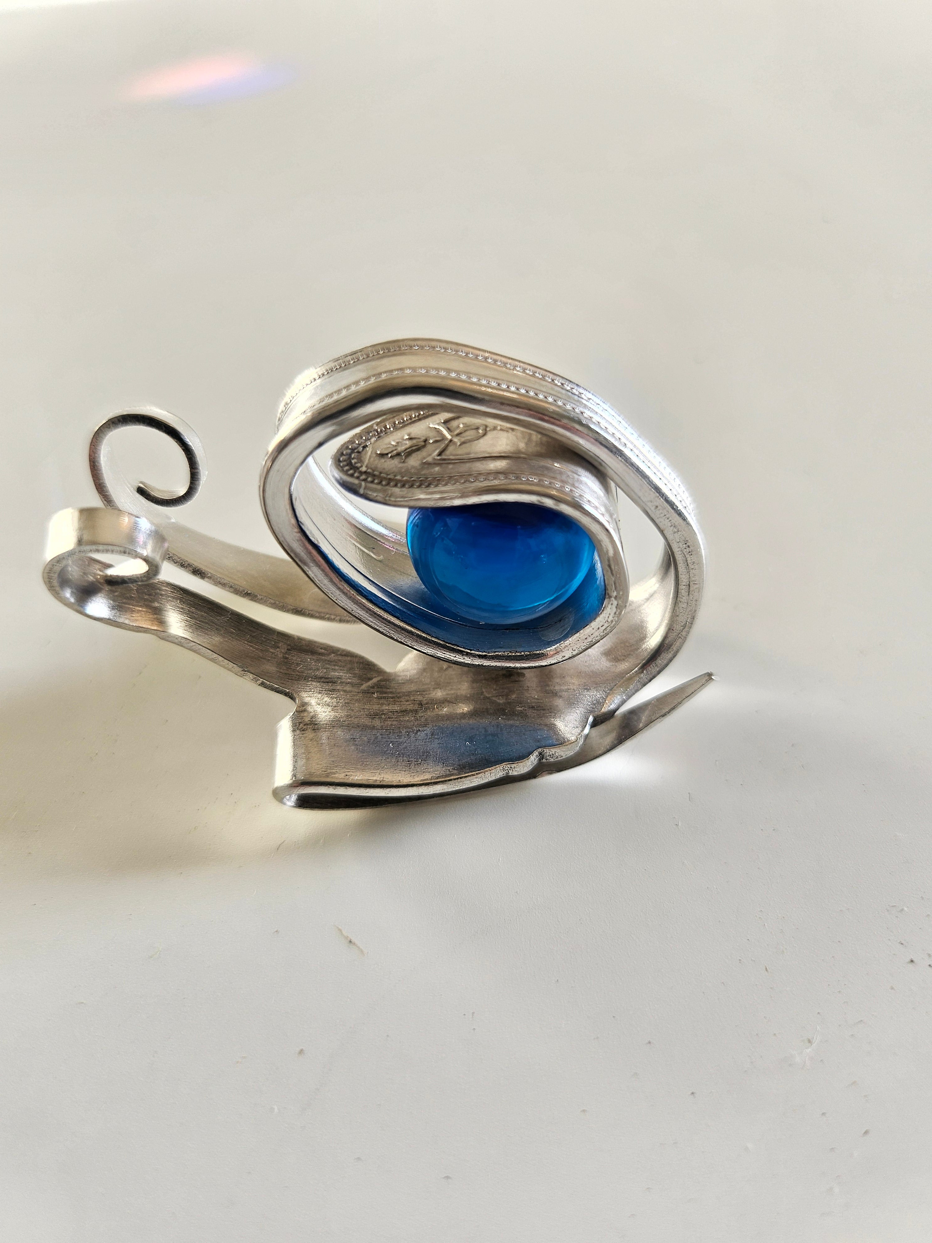 Handcrafted from vintage silverware, these whimsical snails feature shimmering glass orb shells—each a one-of-a-kind symbol of patience and charm.