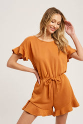 Soft French terry romper with ruffled sleeves, elastic waist, pockets & back button closure. Comfy, cute, and perfect for sunny days or casual outings.