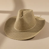 Braided cord band cowboy hat featuring woven paper straw texture and soft curved brim. Lightweight boho western style perfect for beach days, festivals, and summer outfits.
