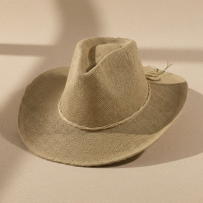 Braided cord band cowboy hat featuring woven paper straw texture and soft curved brim. Lightweight boho western style perfect for beach days, festivals, and summer outfits.