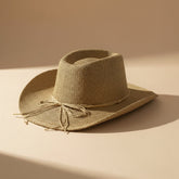 Braided cord band cowboy hat featuring woven paper straw texture and soft curved brim. Lightweight boho western style perfect for beach days, festivals, and summer outfits.