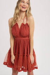 Terracotta gauze swing mini dress with halter tie bust, backless design, elastic waist, and mesh ruffle hem. Lightweight summer party dress.